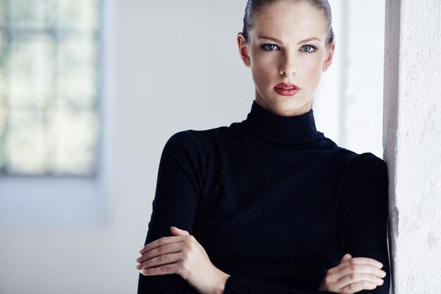 Slim brunette woman in black sweater. Crossed arms.