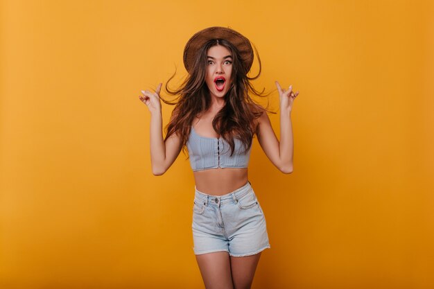 Slim excited girl with long dark hair having fun  with yellow interior