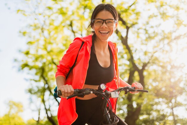 Slim fit beautiful woman doing sports in morning in park riding