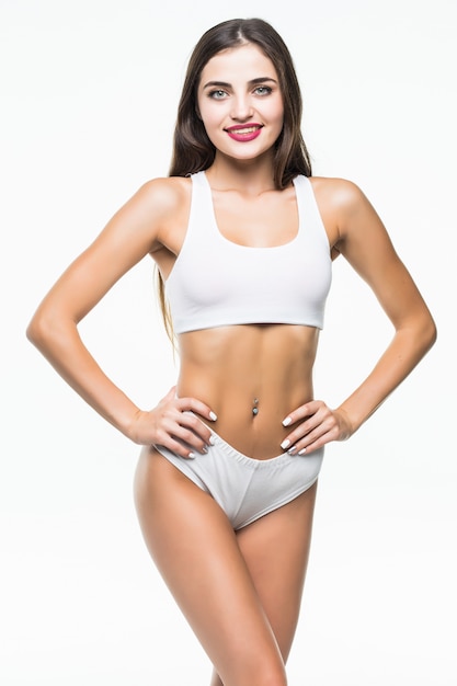 Slim tanned woman's body isolated over white wall.