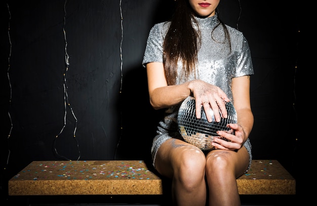 Slim woman in dress with disco ball