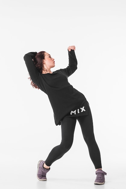 Slim young woman dancing hip hop against white background