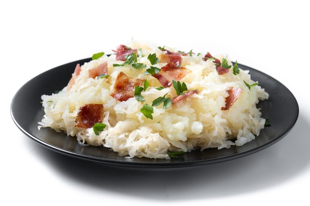 Slovak potato dumplings halusky with steamed sauerkraut and bacon isolated on white background