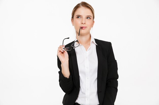 Sly pensive blonde business woman holding eyeglasses and looking up over white 