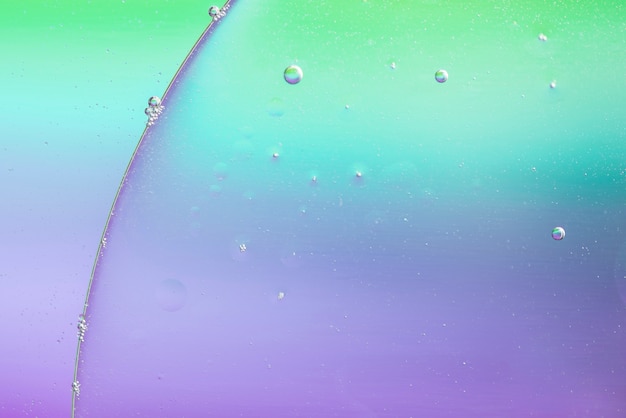 Бесплатное фото Маленькие пузырьки воздуха на большой капле масла на фоне воды