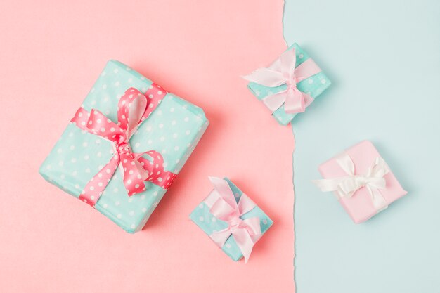 Small and big decorated gift boxed tied with ribbon arrange on peach and blue wallpaper