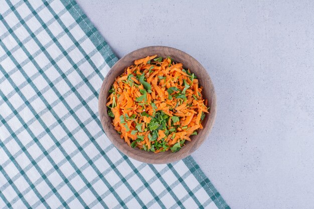 Foto gratuita piccola ciotola di insalata di carote su una tovaglia su sfondo marmo. foto di alta qualità