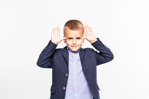 Small boy make fun gesture isolated on white wall