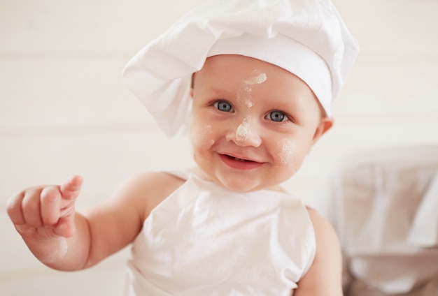 The small boy sits on the table in kitchen