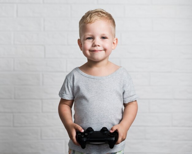 Small boy with joystick looking at camera