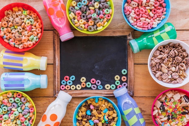 Free photo small bright cereals on chalkboard on wooden table