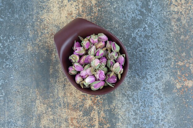 Free photo small budding roses in dark bowl.