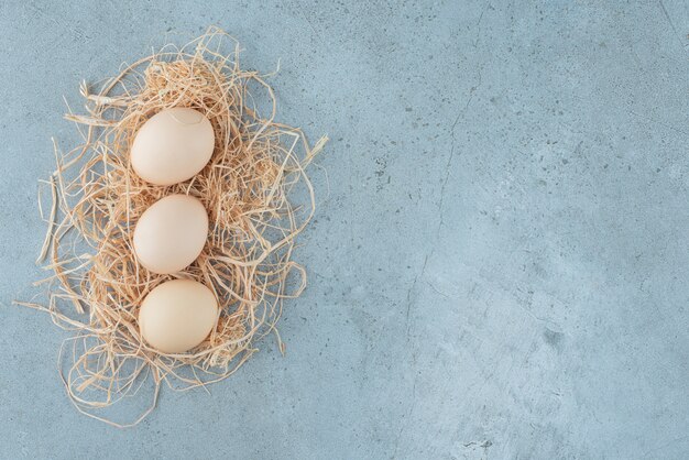 대리석 바탕에 짚의 작은 더미에 계란의 작은 번들. 고품질 사진