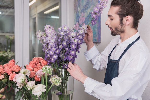 Piccola impresa. fiorista maschio nel negozio di fiori. fare decorazioni e arrangiamenti