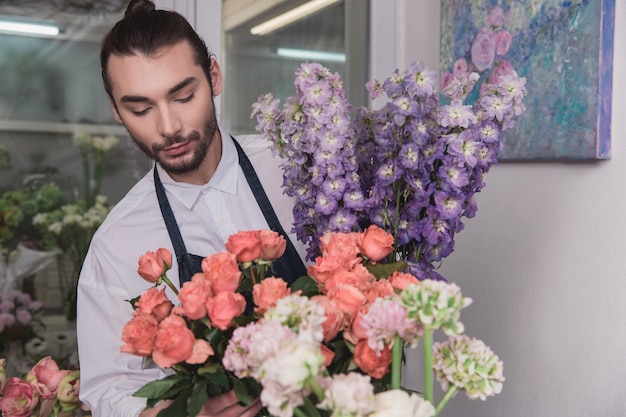 Foto gratuita piccola impresa. fiorista maschio nel negozio di fiori.