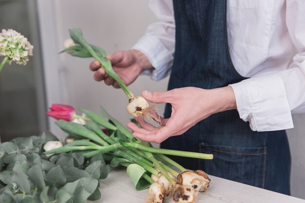 Foto gratuita piccola impresa. fiorista maschio nel negozio di fiori.