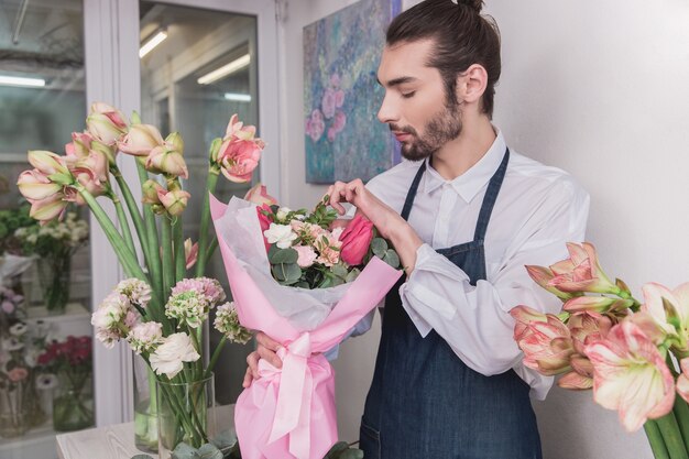 Foto gratuita piccola impresa. fiorista maschio nel negozio di fiori.