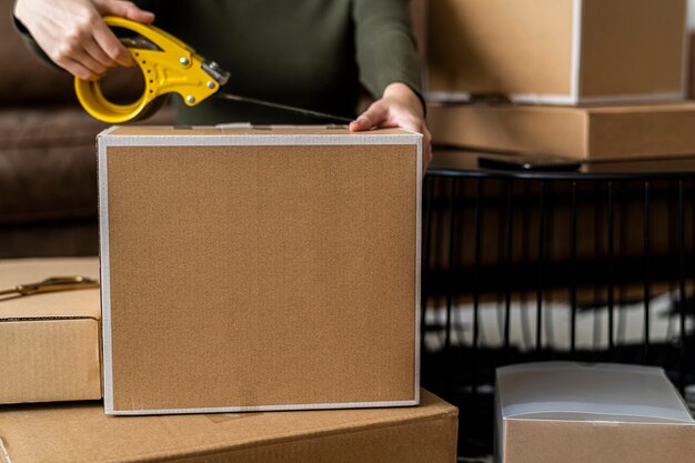 配達のために製品の小包ボックスを梱包する中小企業の所有者