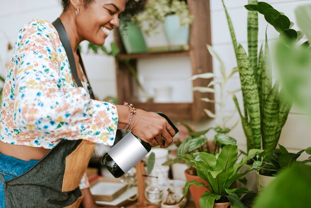 Small business worker misting plants with a water spray