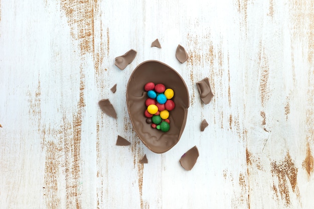 Free photo small candies in open chocolate egg on table