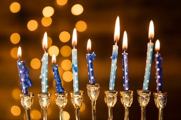 Small candles of menorah near abstract lights