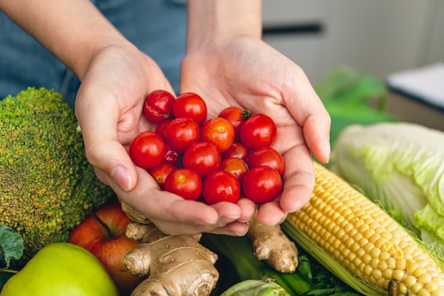 Free photo small cherry tomatoes in women's hands on a blurred background