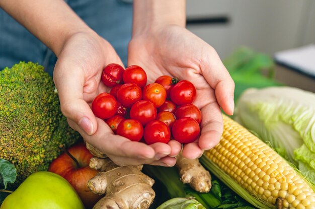 Small cherry tomatoes in women's hands on a blurred background