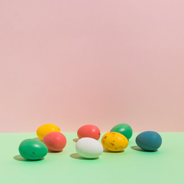 Small colorful Easter eggs scattered on table