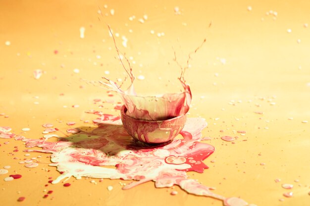 Small cup with mixed paint abstract background