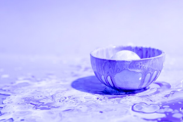 Small cup with purple paint abstract background