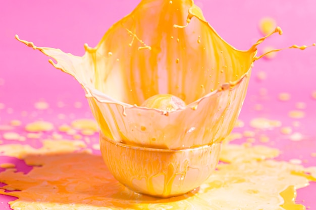 Foto gratuita piccola tazza con sfondo giallo vernice astratta