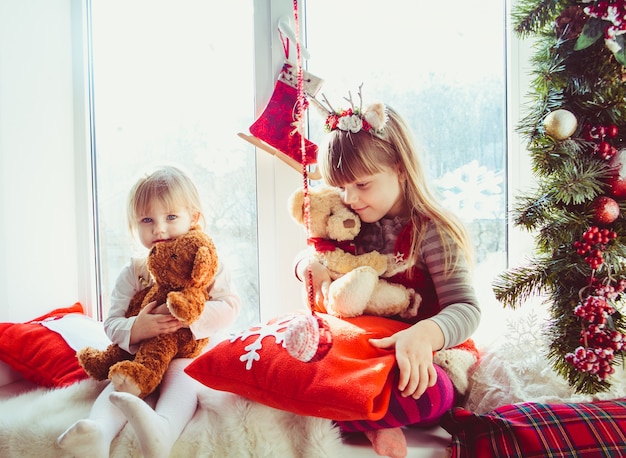 The small daughters sitting on the window-sill