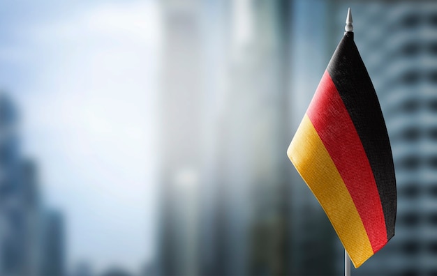 A small flag of Germany on blurred city