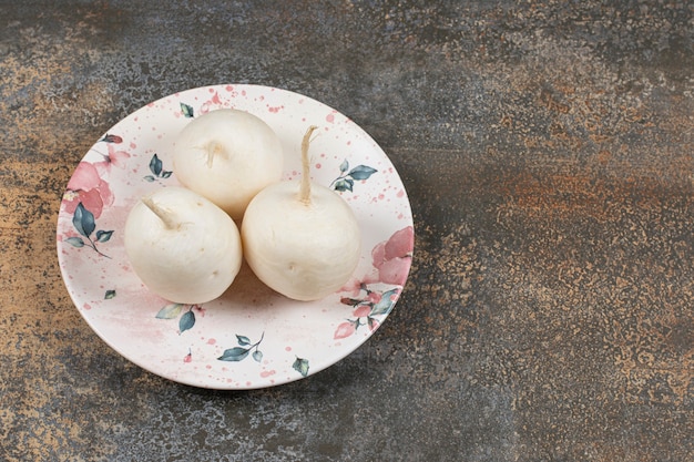 Small garden radish on the plate , on the marble surface