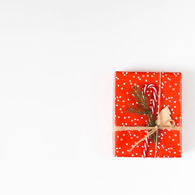 Free photo small gift box with candy cane on table