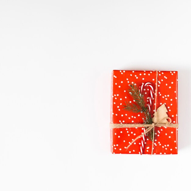 Small gift box with candy cane on table 