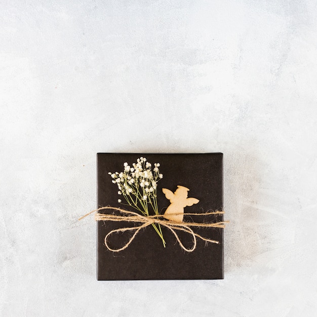 Small gift box with green branch on table