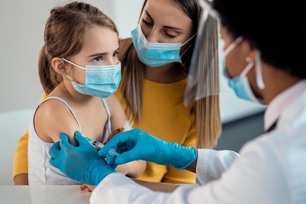 Small girl receiving vaccine during coronavirus pandemic