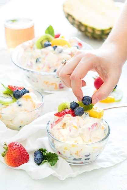 맛있고 크림 같은 과일과 요구르트로 채워진 작은 유리 그릇