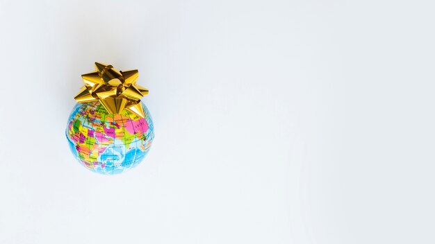 Small globe with yellow bow on table 