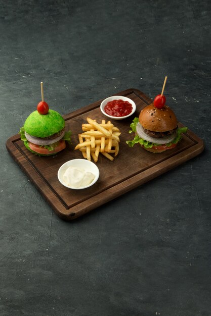 Small green and brown beef burgers served with fries, ketchup and mayonnaise