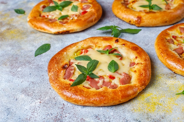 Бесплатное фото Маленькие домашние пиццы свежие с базиликом.
