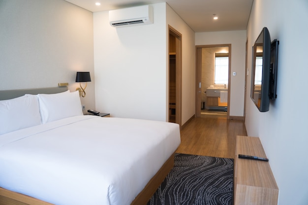 Small hotel room interior with double bed and bathroom. 