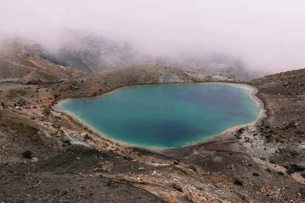 霧の日に山の近くの砂漠の真ん中にある小さな湖