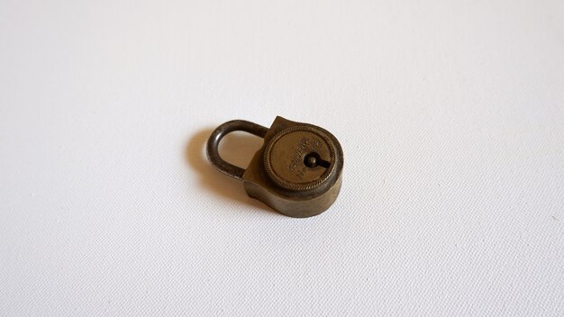 白い表面に置かれた小さな金属製の錠