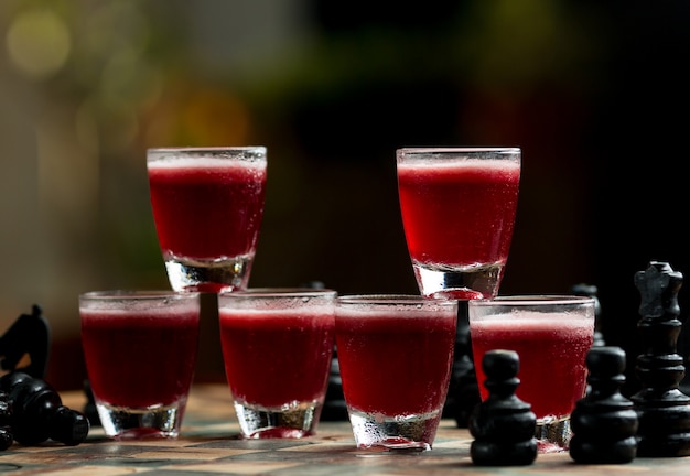 Free photo small multiple glasses of red drinks in the bar stand