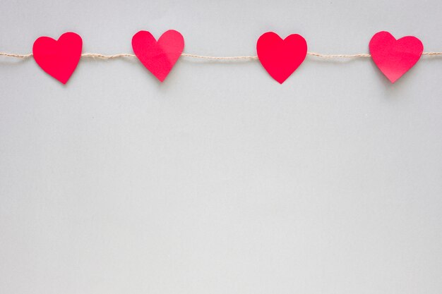 Small paper hearts pinned to rope 