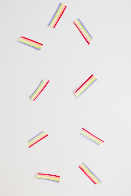 Foto gratuita piccoli arcobaleni di carta sparsi sul tavolo