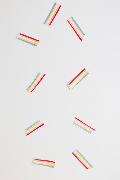 Small paper rainbows scattered on table