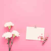 Free photo small paper sheet with white flowers on table